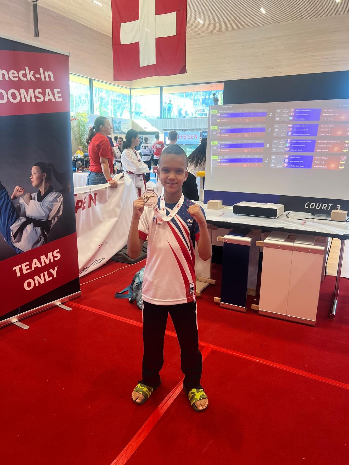 Kind mit Medaille Taekwondo Glarus